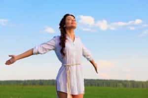 Young happy woman in green field